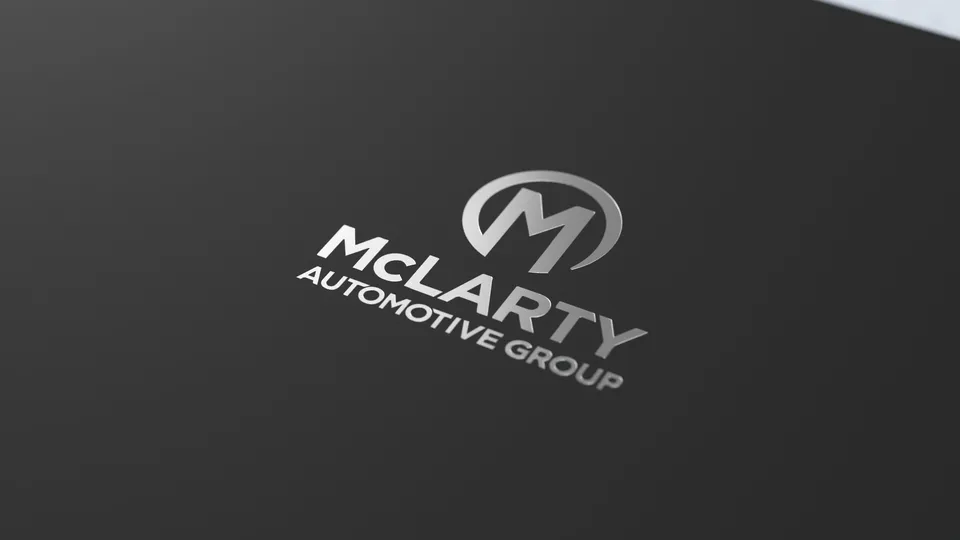 Foil-stamped McLarty Automotive Group logo on matte black leather